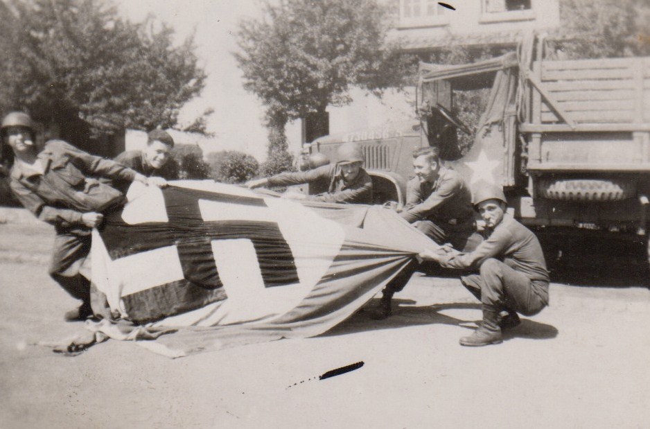 Five members of the 139th Airborne Engineer Battalion, 17th Airborne Division display a large Nazi flag tha t they have just captured. This was taken around April 1945 near the town of Essen.